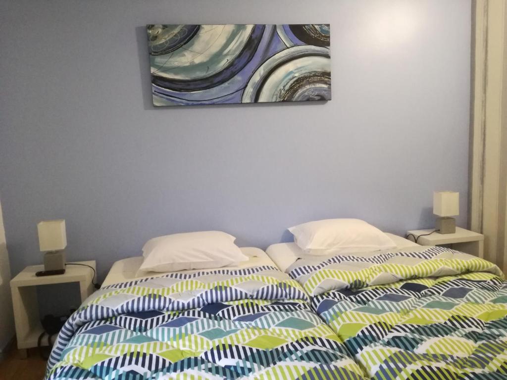 1 dormitorio con 1 cama con una pintura en la pared en Hospedaria 5 Bicas, en Aveiro