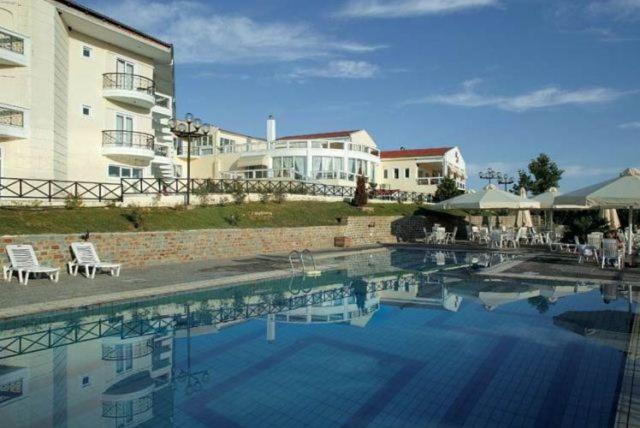 a large swimming pool in front of a building at Hotel Αchillion Grevena in Grevena