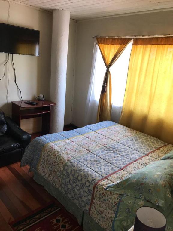 a bedroom with a bed and a window at Hospedaje Freire in Osorno