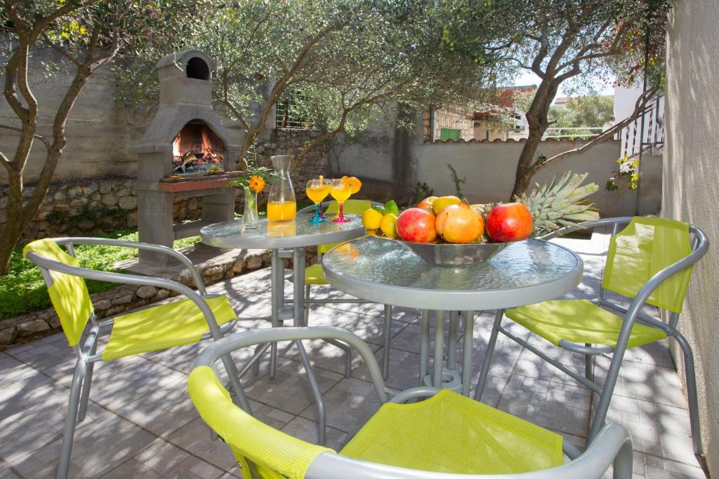 2 mesas y sillas con fruta en un patio en Great Located Family Apartments, en Marina