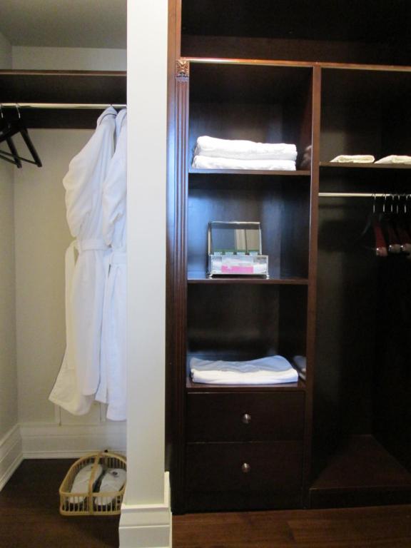 a closet with a wooden book shelf with towels at Sydney Boutique Inn & Suites in Charlottetown