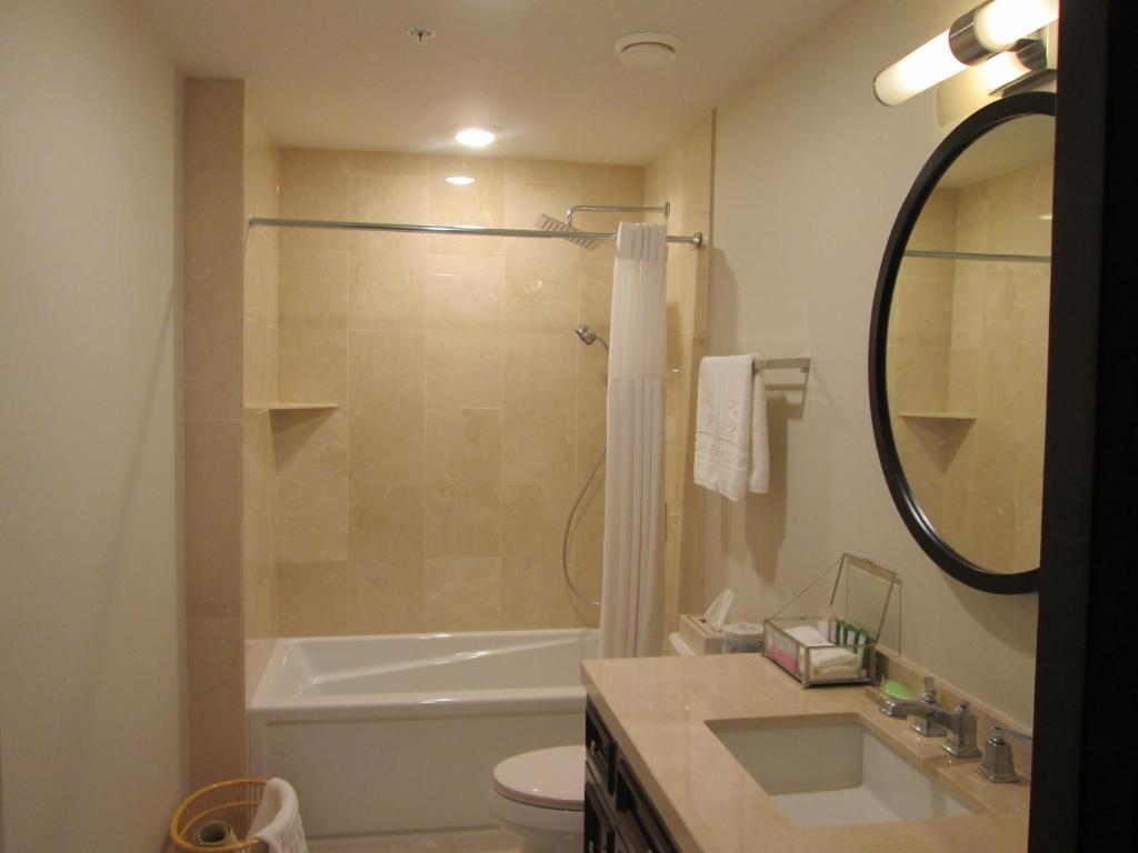 a bathroom with a tub and a toilet and a sink at Sydney Boutique Inn & Suites in Charlottetown
