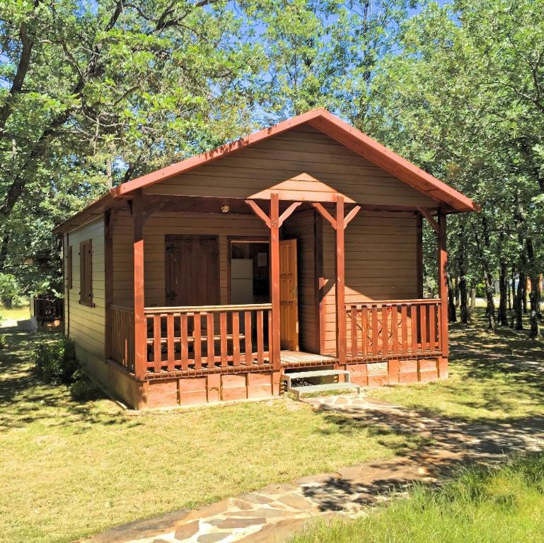 Cabaña pequeña con porche en el césped en Camping Riaza, en Riaza