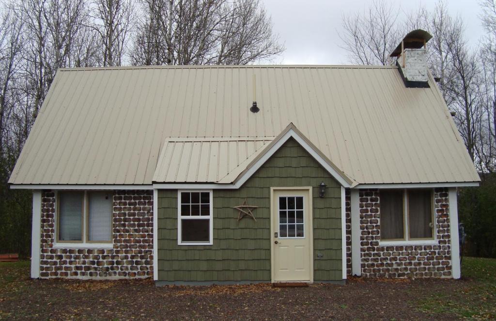 Husky House في Bessemer: منزل أخضر صغير بسقف وباب