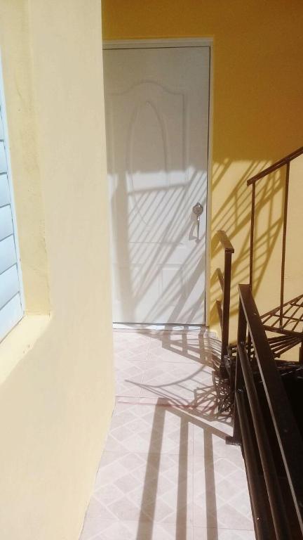 a hallway with a door in a building with a staircase at Casa Vasquez in San Felipe de Puerto Plata