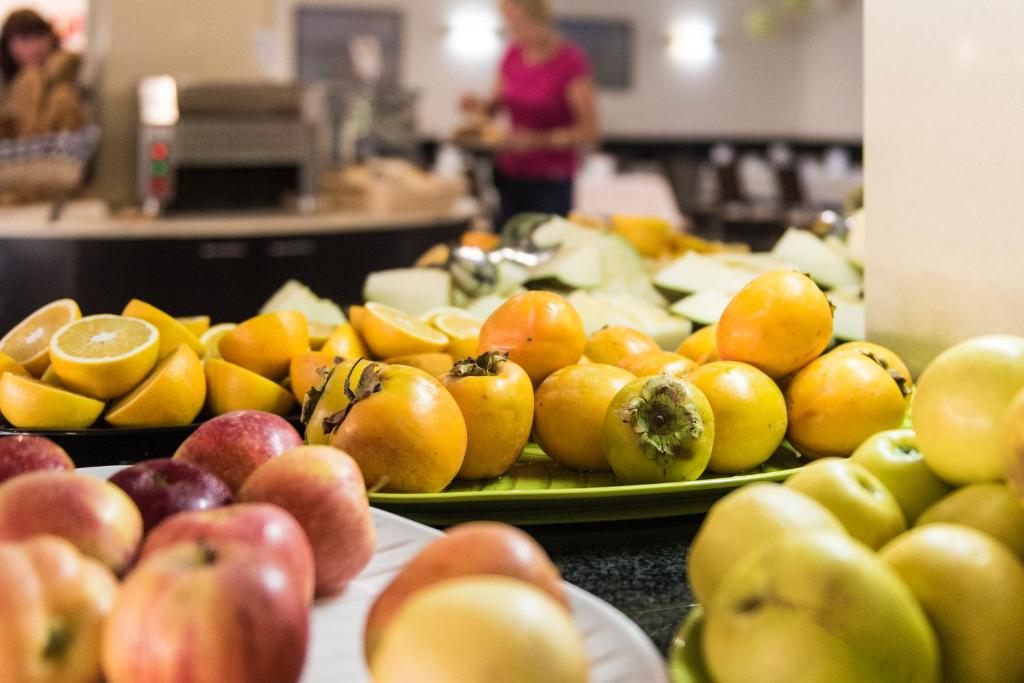a table topped with plates of apples and oranges at Hotel Lanzarote Village in Puerto del Carmen
