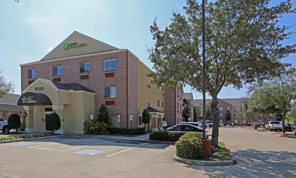 um edifício de hotel com uma árvore num parque de estacionamento em Extended Stay America Suites - Houston - Katy Freeway - Energy Corridor em Houston