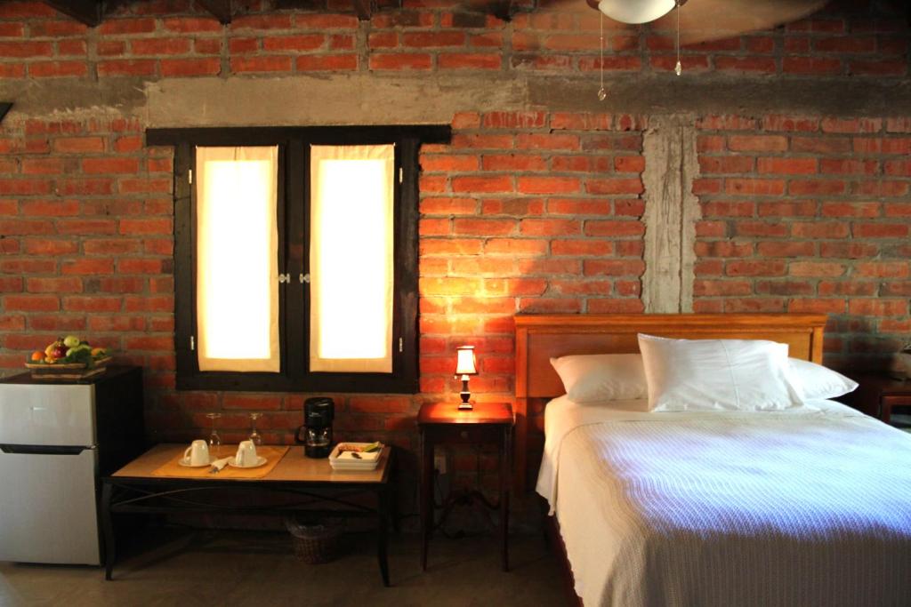 a bedroom with a bed and a brick wall at Las Orquideas Cabins in Valle de Guadalupe