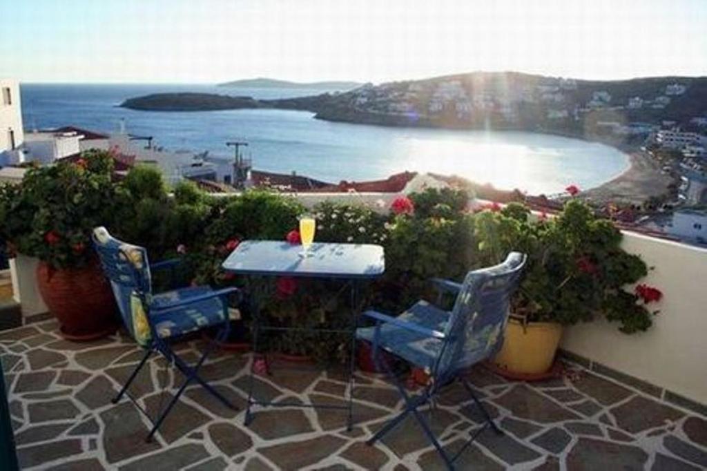 uma mesa e cadeiras numa varanda com vista para o oceano em Meltemi em Batsi