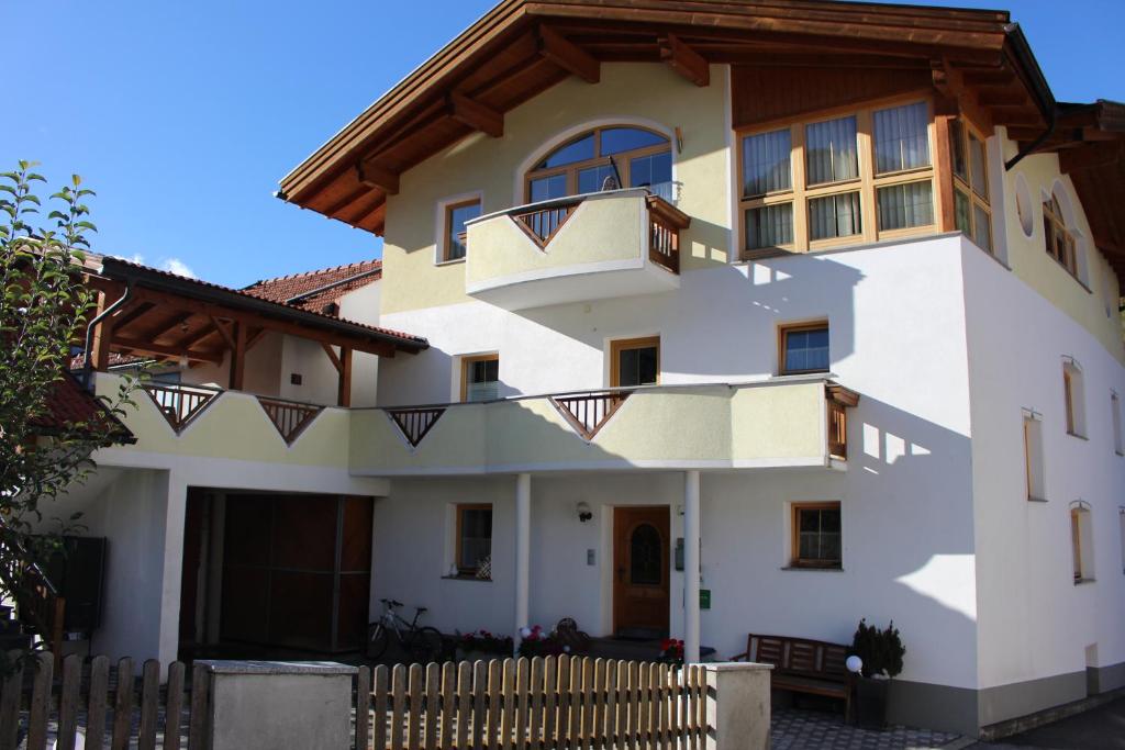 una gran casa blanca con una valla de madera en Aktiv Apart Stöckl, en Kauns