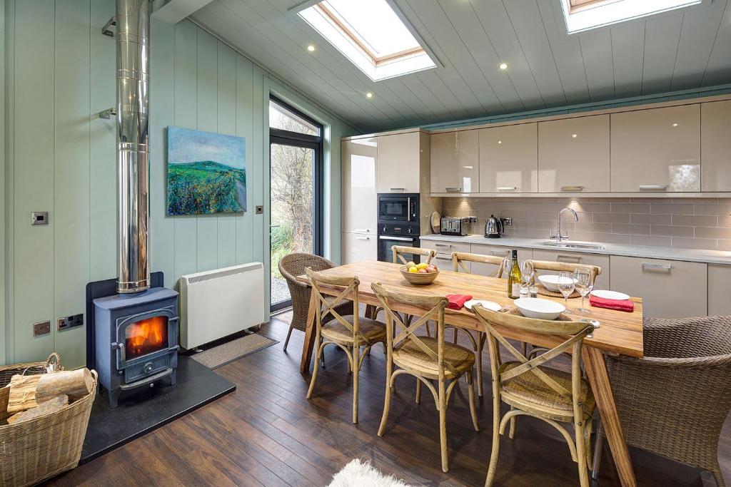 a kitchen with a wooden table and a wood stove at Aberdaron Lodge in Aberdaron