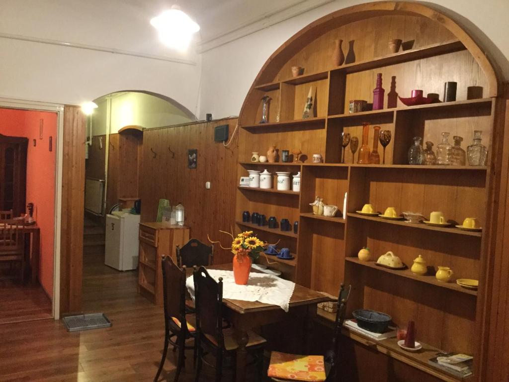a dining room with a table and shelves with shoes at Bazilika Vendégház in Eger