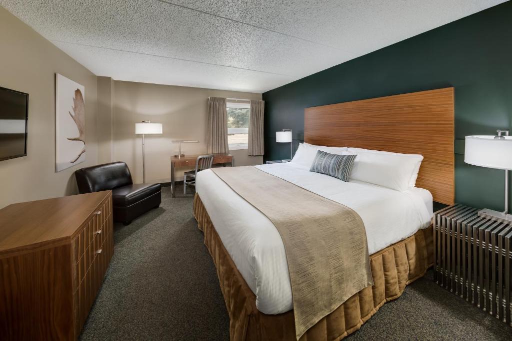 Habitación de hotel con cama grande y escritorio. en Heritage Inn Hotel & Convention Centre - Moose Jaw, en Moose Jaw