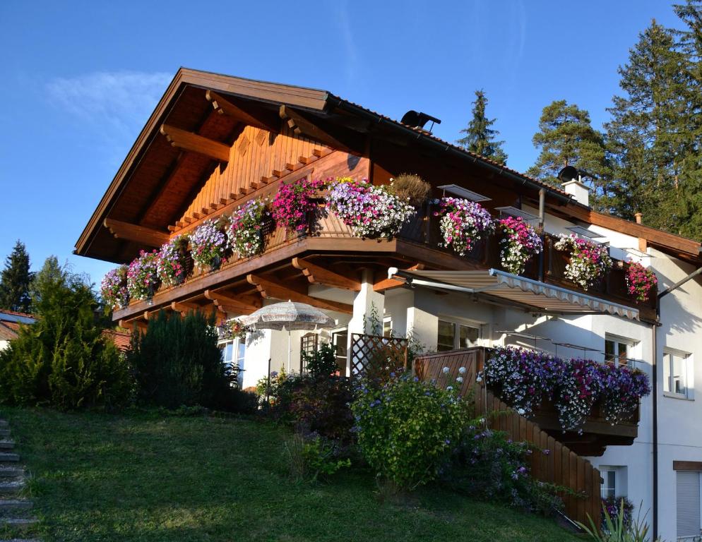 ein Gebäude mit vielen Blumenkästen darauf in der Unterkunft Landhaus am Golfplatz in Seefeld in Tirol