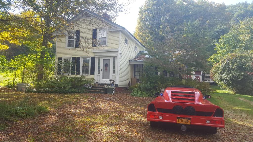 un camion rouge garé devant une maison blanche dans l'établissement A Meadow House, à Lakeville