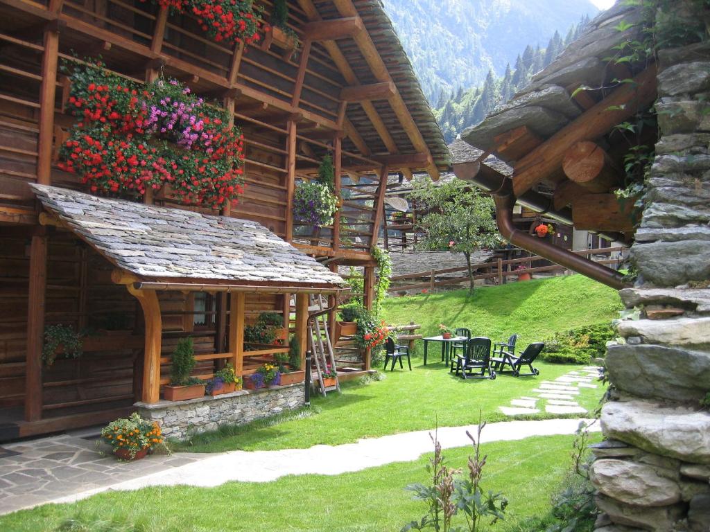 a building with a table and chairs in a yard at Baita Reale in Alagna Valsesia