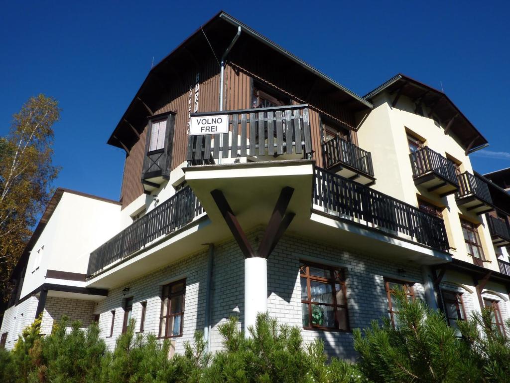 a building with a balcony on top of it at Pension Borůvka in Špindlerův Mlýn