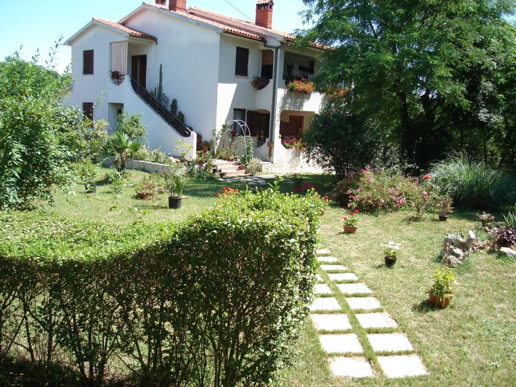 a house with a garden with a pathway in the yard at Apartments Valoda in Nedeščina