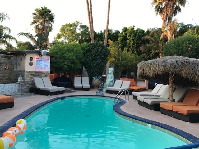 una piscina con tumbonas y sillas en un complejo en Sea Mountain Nude Resort & Spa Hotel - Adults Only en Desert Hot Springs
