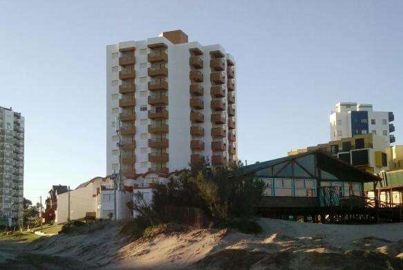 un edificio alto en la playa junto a un edificio en Arpon 9 - 5C - Frente al mar 2 duerme.  cochera privada en Villa Gesell