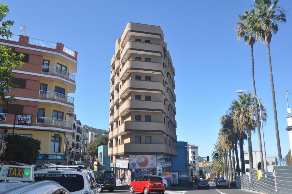 un edificio alto en una calle de la ciudad con palmeras en Piso en Icod de los Vinos, en Icod de los Vinos