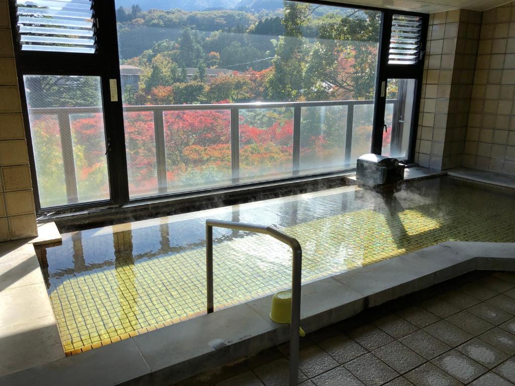 uma piscina num edifício com uma grande janela em Suikoukan em Hakone
