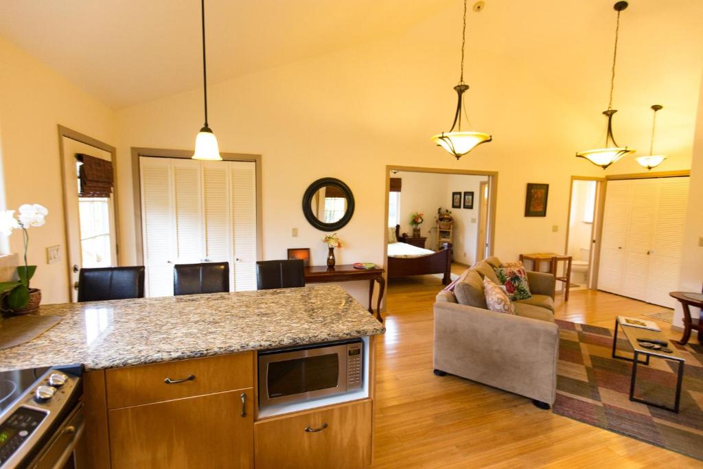 cocina y sala de estar con sofá y mesa en Kuuipo Cottage, en Mountain View