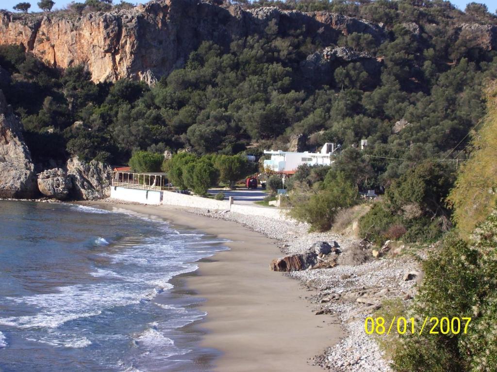 a beach next to the water with a mountain at Nikos & Anna Rooms in Rodakino