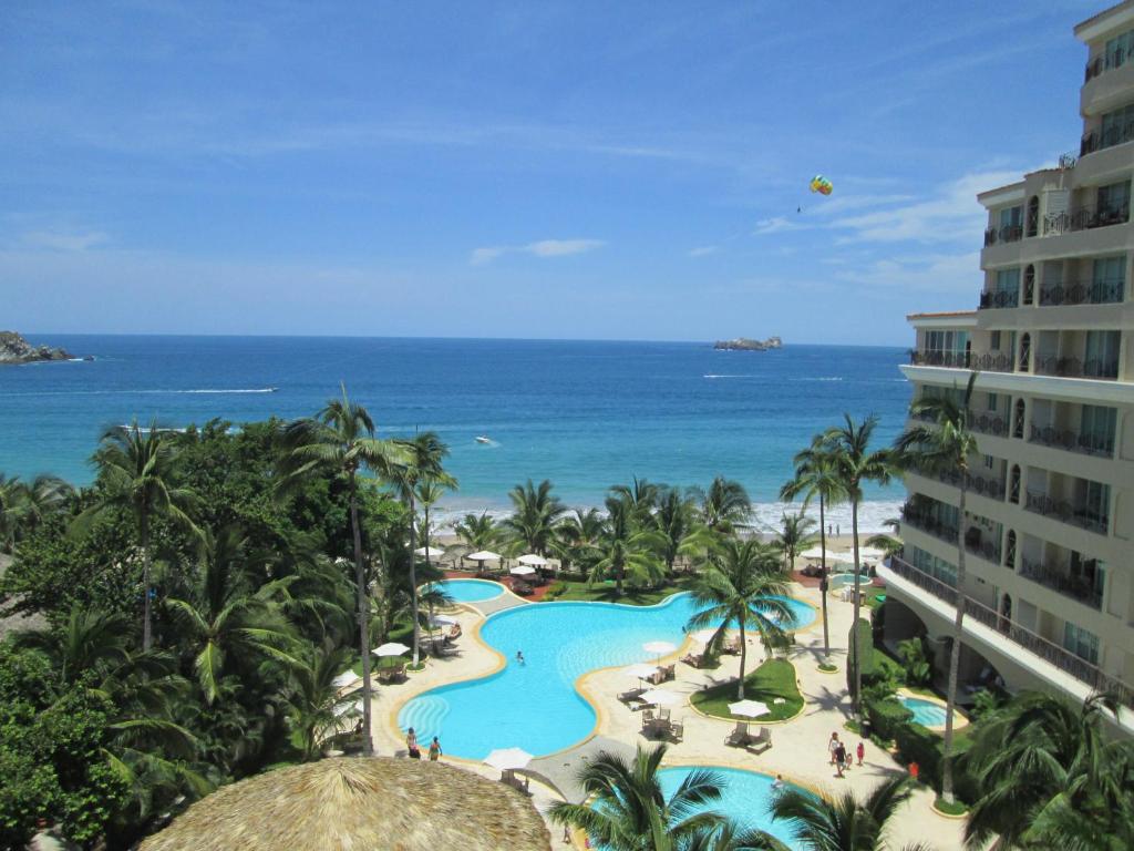 a view of a resort with a pool and the ocean at Bay View Grand Residencial 602 Sur in Ixtapa