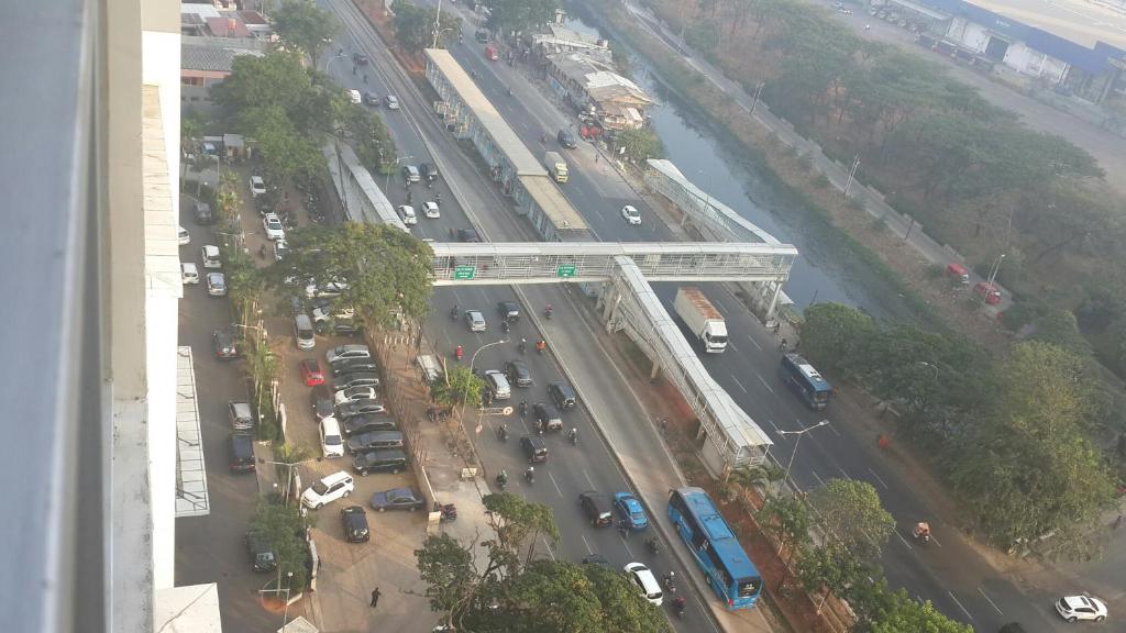 een luchtzicht op een straat met auto's en een brug bij Robert's Callia at East Jakarta in Jakarta