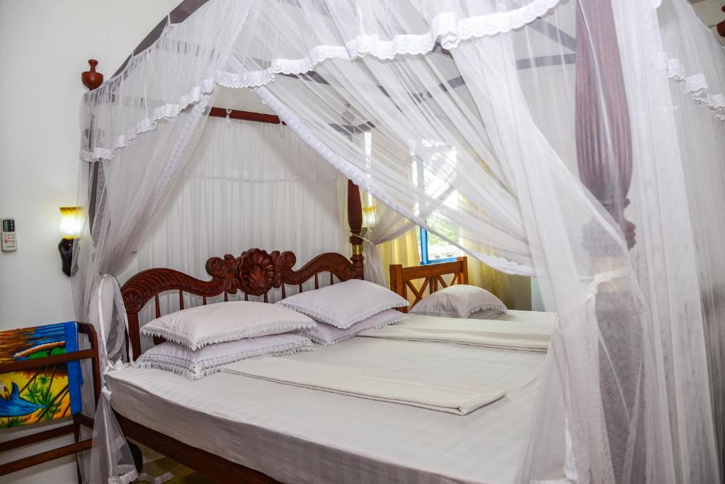 Rúm í herbergi á Hotel Dolphin Hikkaduwa
