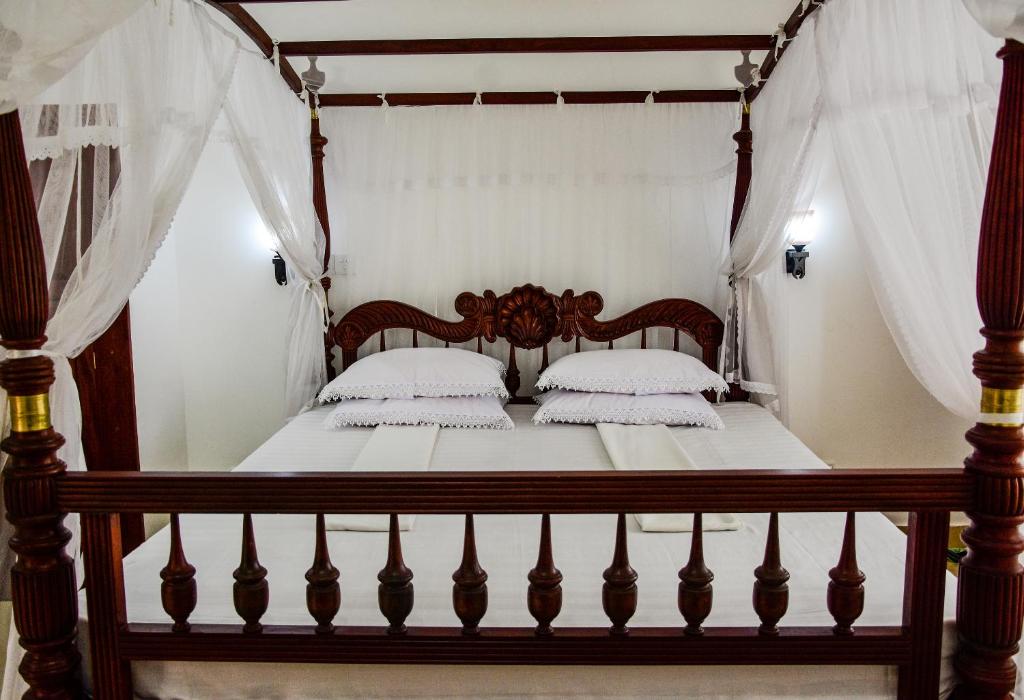 Rúm í herbergi á Hotel Dolphin Hikkaduwa