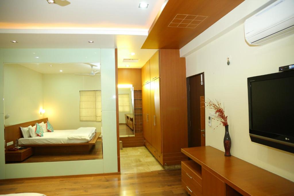 1 dormitorio con 1 cama y TV en una habitación en Swan Suites Madhapur, en Hyderabad