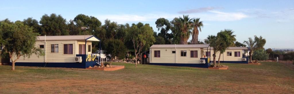 dos casas móviles en un campo con árboles en Drummond Cove Holiday Park, en Drummond Cove