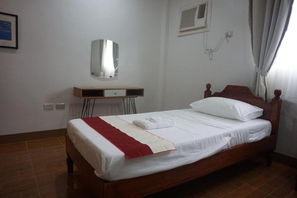 um quarto com uma cama com lençóis brancos e uma janela em Lugano Bed and Breakfast em Santa Ana