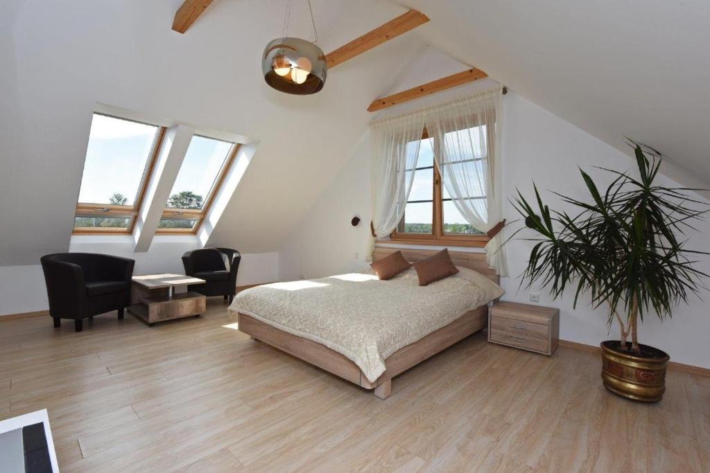 a bedroom with a bed and a potted plant at Prie Žiedo in Trakai