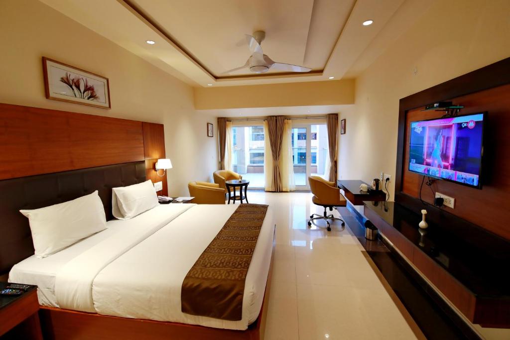 a hotel room with a large bed and a television at Southern Star,Davangere in Dāvangere