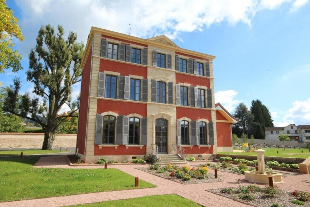 a large red brick building with a yard at Chambre D’hôtes Parc Johan in Chauffailles