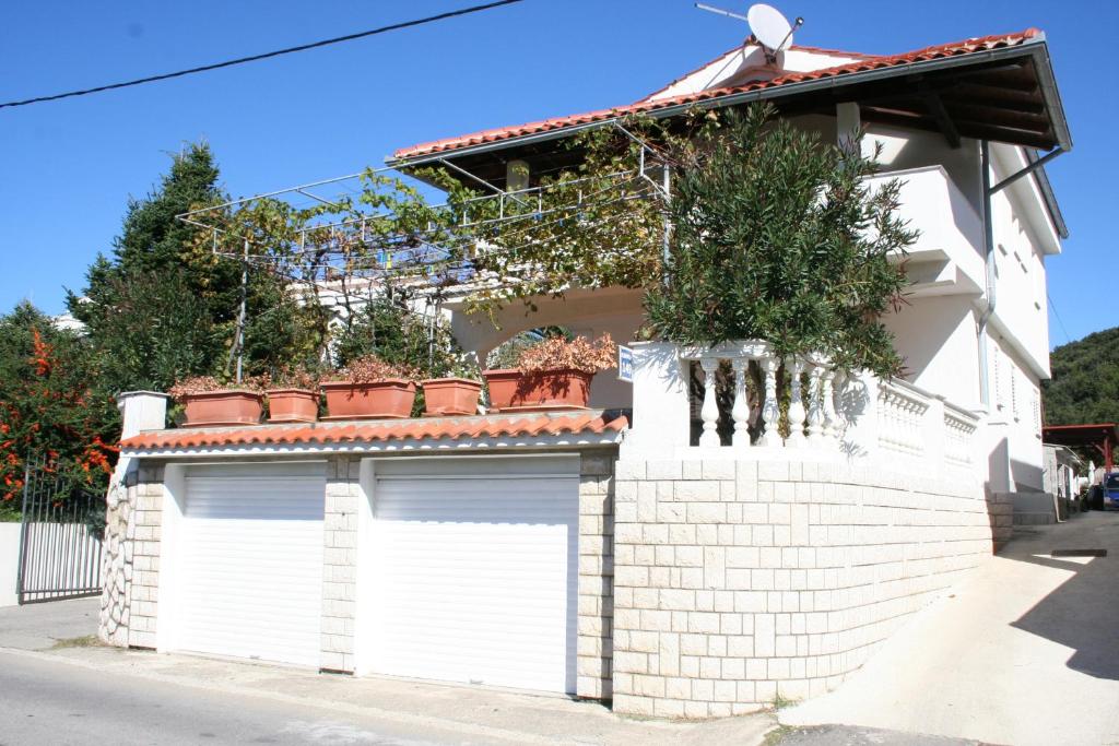 a white garage with plants on top of it at Apartments Galic in Rab