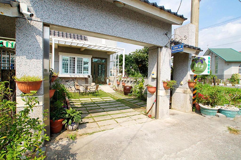 un portico anteriore di una casa con piante in vaso di Vineyard Guest House a Città di Taitung