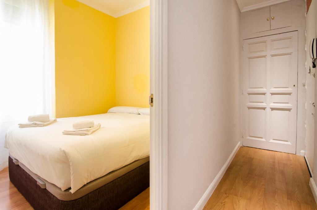 a bedroom with a bed with yellow walls at Espiritu Santo 11 in Madrid