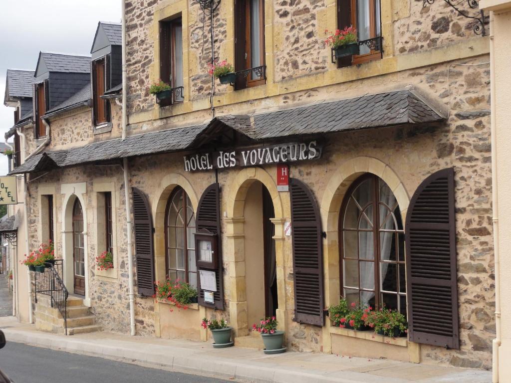 a building with a sign that reads hotel kiss yourselves at Hotel des Voyageurs in Payzac