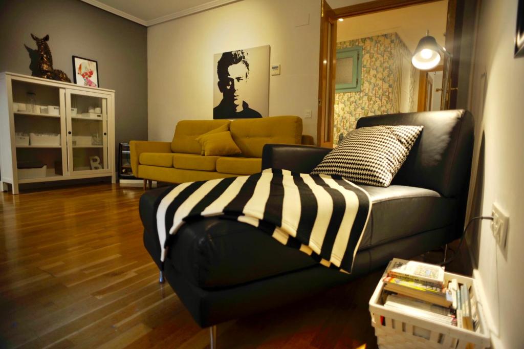 ein Wohnzimmer mit einem schwarz-weißen Sofa in der Unterkunft Pasaje al Pilar in Saragossa