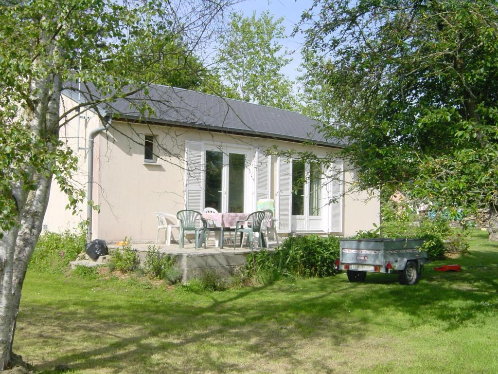 ein weißes Haus mit einem Tisch und Stühlen im Hof in der Unterkunft La maison dans le pré in Agon Coutainville