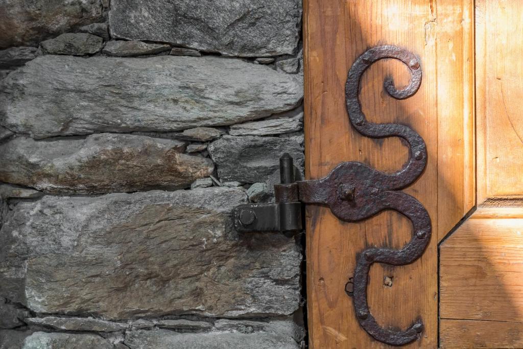 a wooden door with a snakes handle on a stone wall at Hotel Montpelier in Verbier
