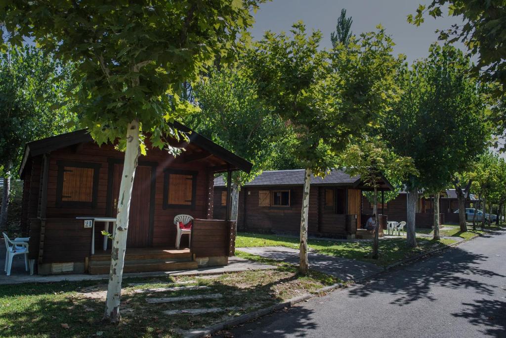 a log cabin in the middle of trees at Camping & Bungalows Ligüerre de Cinca in Ligüerre de Cinca
