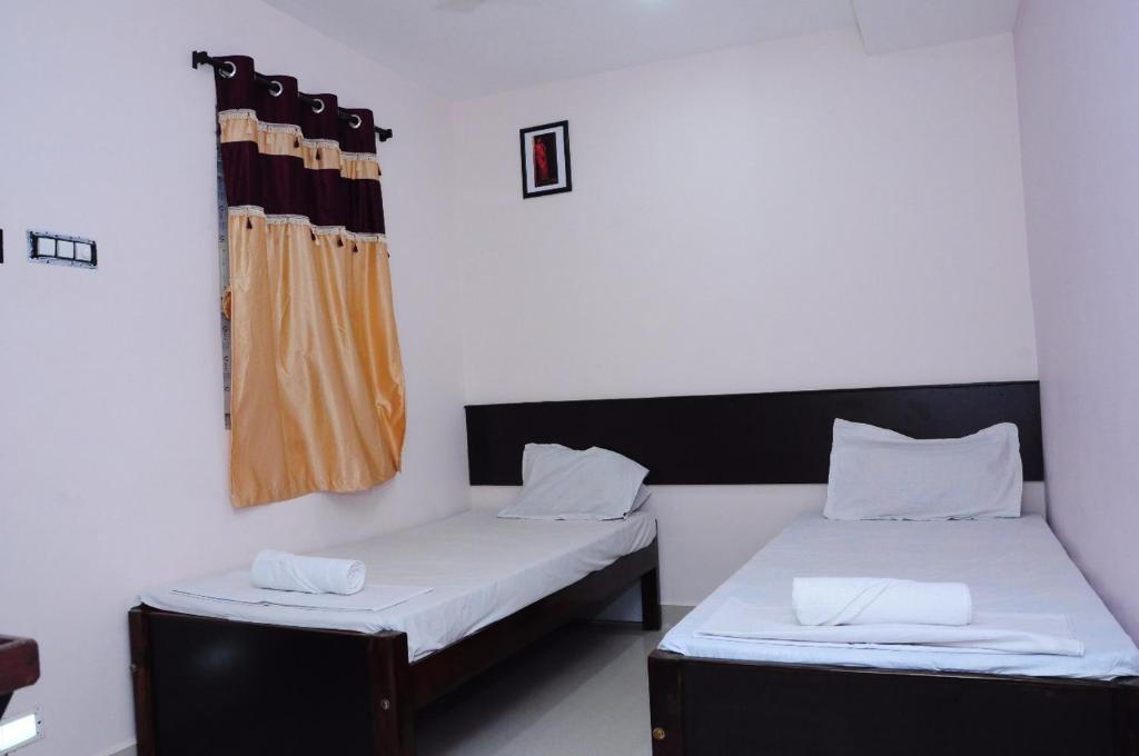 Zimmer mit 2 Betten und einem Fenster in der Unterkunft SGS Residency in Tirupati