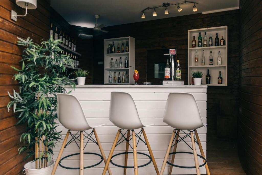 a bar with three stools in front of a counter at Velamar Boutique Hotel - Adults Friendly in Albufeira
