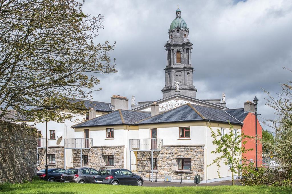 un grand bâtiment avec une tour d'horloge en haut dans l'établissement Cathedral View Apartments, à Longford