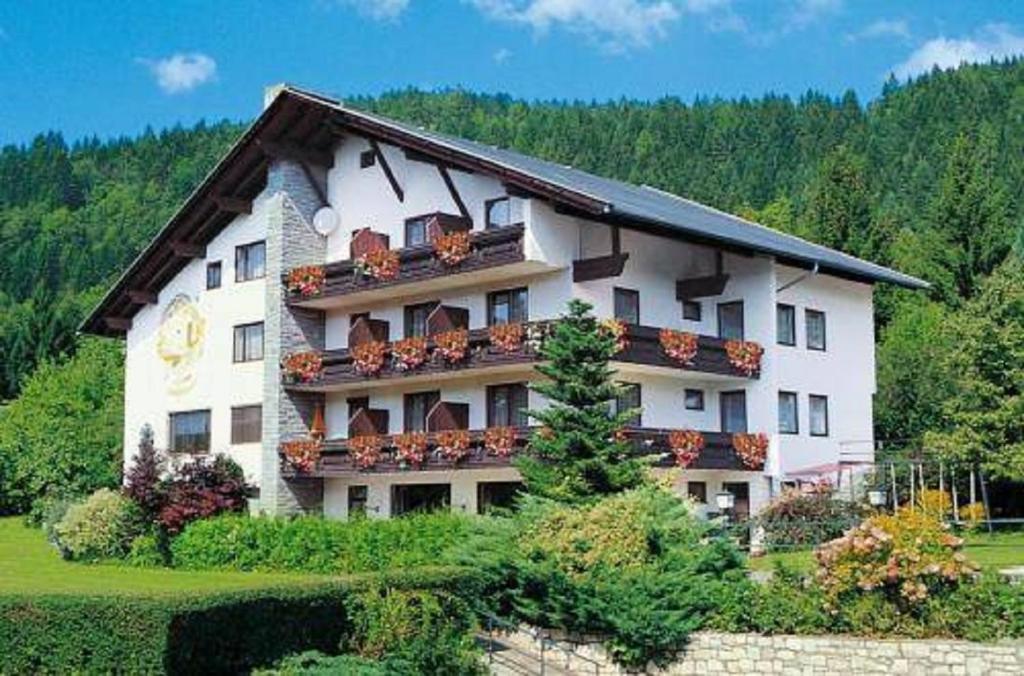 ein großes Gebäude mit Balkonen und einer Uhr darauf in der Unterkunft Appartementhaus Sonne in Millstatt